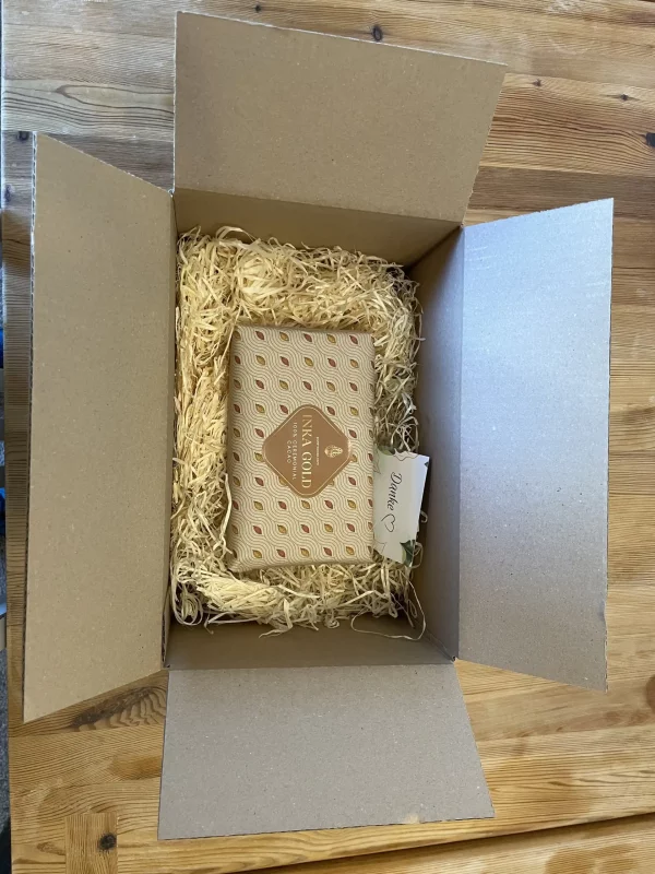 Inka Gold 500g ceremonial cacao block carefully packed in a cardboard box with eco-friendly straw filling.