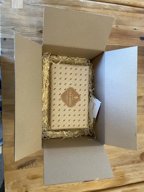 Inka Gold 1kg ceremonial cacao block carefully packed in a cardboard box with natural filling material.